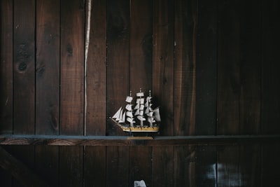 棕色木架上的黑色、棕色和白色帆船船型模型